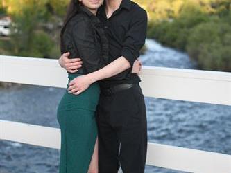 Couple posing on the bridge for a photo . 