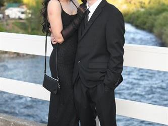 Couple posing on the bridge for a photo. 