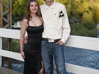 Couple standing on the bridge for a photo. 