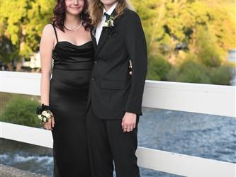 Couple posing on the bridge for a photo.