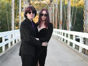 Couple posing on the bridge for a photo. 