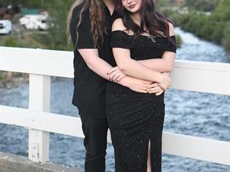 Couple posing on the bridge for a photo. 