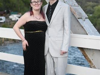 Couple posing on the bridge for a photo. 