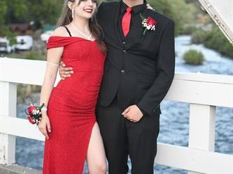 Couple posing on the bridge for a photo.